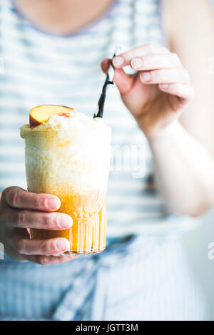 Bright and colorful Ice cream float being held in a womans hands Stock Photo