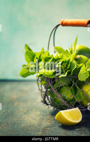 Mojito cocktail ingredients (fresh mint, lime, ice) on rustic background Stock Photo