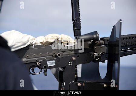 PACIFIC OCEAN (July 9, 2017) - A Sailor loads an M-240 machine gun during a live-fire exercise aboard the amphibious transport dock ship USS San Diego (LPD 22). San Diego is embarked on a scheduled deployment as part of the America Amphibious Ready Group, which is comprised of more than 1,800 Sailors and 2,600 Marines assigned to the amphibious assault ship USS America (LHA 6), the amphibious dock landing ship USS Pearl Harbor (LSD 52) and San Diego. (U.S. Navy photo by Mass Communication Specialist 1st Class Joseph M. Buliavac/Released) Stock Photo