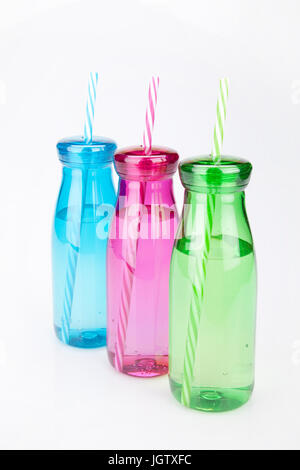 Colorful plastic tumblers on a white surface. Tumblers isolated on white background. Stock Photo
