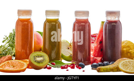 Selection of different energising fruit smoothies in four bottles surrounded by fresh ingredients with pear, orange, watermelon, pomegranate, kiwi, ma Stock Photo