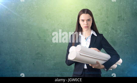 Building, developing, consrtuction and architecture concept - beautiful businesswoman in suit with blueprint. Stock Photo