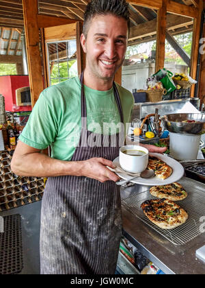 Farmer and chef Mitchell Morse, owner of Fickle Fig Farm outside Victoria, BC, Canada, on Vancouver Island. Here he holds a plate with his organic chi Stock Photo
