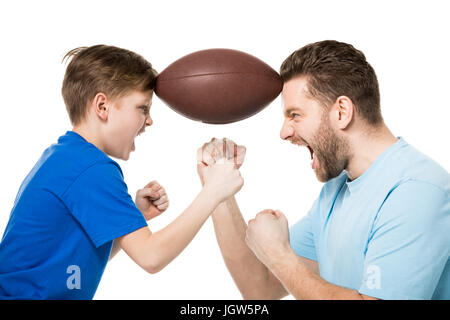 Side view of father with son screaming and holding rugby ball between faces isolated on white Stock Photo