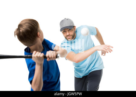 Boy ready to hit the ball during a baseball game. Father and child playing baseball isolated on white Stock Photo