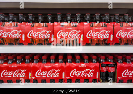Multi-pack glass and plastic bottles of Coca Cola / Coke for sale on a supermarket shelf in the UK Stock Photo