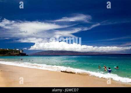 Tourists enjoying the beach at Kaanapali Beach on Maui with view towards Lanai in Hawaii, USA. Stock Photo