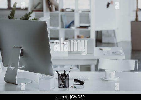 workplace with computer monitor, coffee cup and office supplies in office Stock Photo