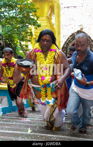 Hindu pilgrim with fire stove kavaldi climbing the batu cave temple staircase, Kuala Lumpur Malaysia during Thaipusam festival on 3rd FEB 2015. Stock Photo