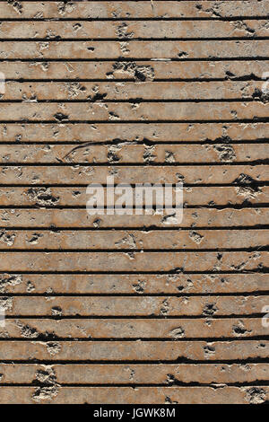 Close-up of a grooved section of sidewalk, where the incised lines run straight across the vertical photo; good for background, wall paper. Stock Photo