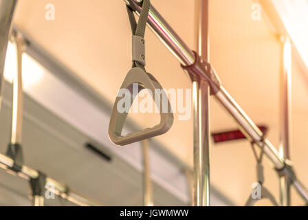 Handles on ceiling for standing passenger inside a bus. Stock Photo