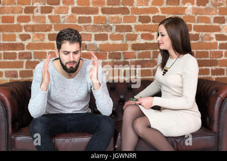 Young couple fighting over money at home on sofa Stock Photo
