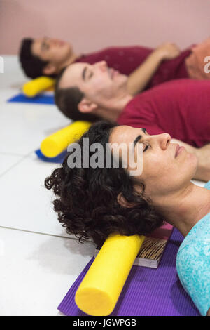 People at yoga class resting head on block Stock Photo