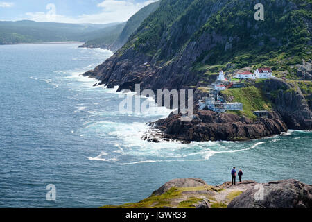 Couple looking out from coastal cliff, St John's, Newfoundland, Canada Stock Photo