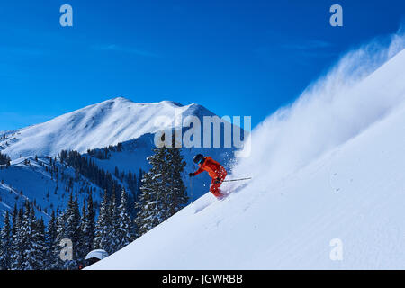Man skiing down steep snow covered mountainside, Aspen, Colorado, USA Stock Photo