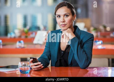 Businesswoman using mobile phone in cafe Stock Photo