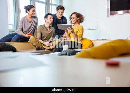 Digital designers on office sofa looking at digital tablet Stock Photo