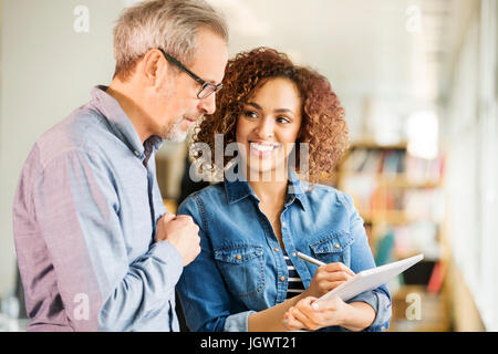 Female and male digital designers making notes in office Stock Photo