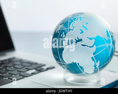 Globe and laptop on desk Stock Photo