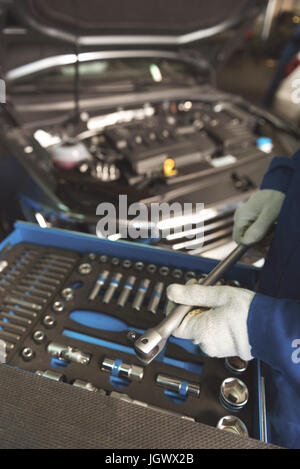 Everything in its place. Competent trained careful man cleaning the instrument and putting it in its box after using it for car reparation Stock Photo