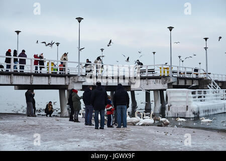 People on the beach and pier in Gdansk Brzezno, Poland, January 2016. Stock Photo