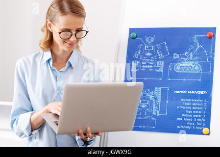Minutes of self improvement . Thoughtful charming positive engineer analyzing the project and creating engineering scheme while working in the office  Stock Photo