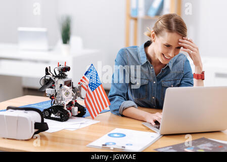 Enjoying my modernized workplace. Attentive smart intelligent engineer working on the project in the office while typing and using laptop Stock Photo