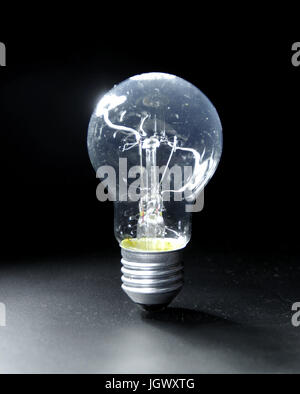 Classic electric bulb on black background. Old lightbulb. Stock Photo