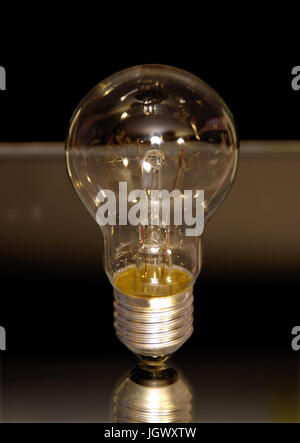 Classic electric bulb on black background. Old lightbulb. Stock Photo