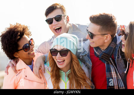 happy teenage friends in shades laughing outdoors Stock Photo