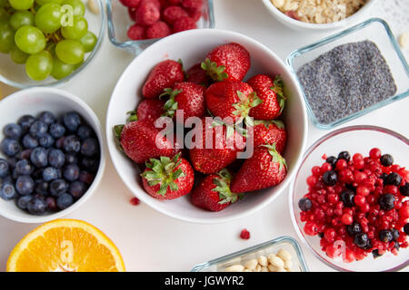 fruits and berries in bowls on table