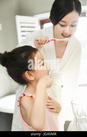 Mother teaching daughter brushing teeth Stock Photo