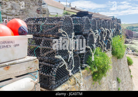 Lobster pots stacked on the sea wall at Hope Cove in the South Hams, Devon Stock Photo