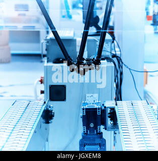 Industrial robot working in factory,Conveyor Tracking Controler of robotic hand. Stock Photo