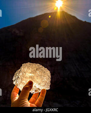 piece of briksdal glacier ice  held in hand in the sunlight Stock Photo