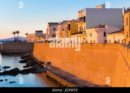 Alghero old town skyline, a view of Alghero at sunset with the great medieval sea wall - the Bastioni Marco Polo - in the foreground, Sardinia. Stock Photo