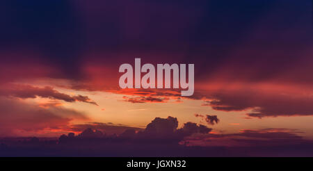 Rays of sun light coming through hole in  purple storm clouds Stock Photo