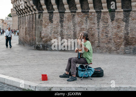 Rome, Italy - August 18, 2016: Musician playing guitar in the streets of Rome at the entrance of Castel Castel Sant Angelo. Stock Photo