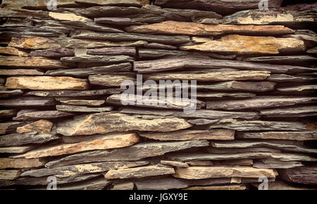 Background wall made of stone. A wall of flat stones laid in several rows Stock Photo