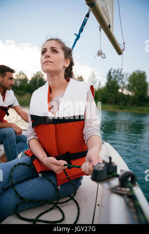 Woman on sailing boat, steering boat Stock Photo