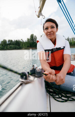 Woman on sailing boat, steering boat Stock Photo