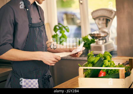 Chef checking delivery note for vegetables Stock Photo