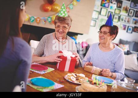 Daughter talking to mother and friend at birthday party Stock Photo
