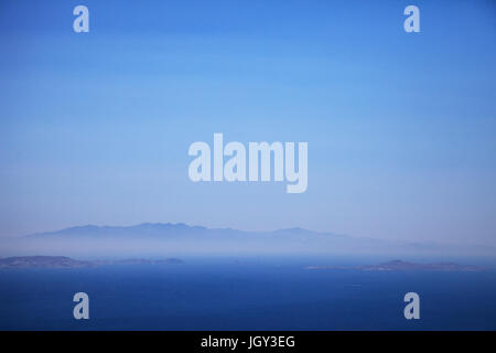 Seascape and distant misty view of Andros Island from Tinos Island, Greece Stock Photo