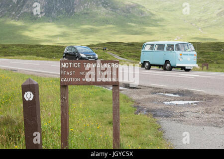 Sign warning West Highland Way walkers to beware of traffic on A82 in Glencoe, Scotland, UK Stock Photo