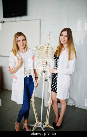 Young doctors having fun by posing with skeleton. Stock Photo