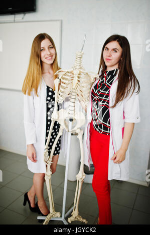 Young doctors having fun by posing with skeleton. Stock Photo