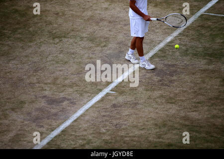 General view of the wear and tear to the grass on the baseline of court fourteen on day eight of the Wimbledon Championships at The All England Lawn Tennis and Croquet Club, Wimbledon. Stock Photo