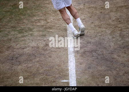 General view of the wear and tear to the grass on the baseline of court eighteen on day eight of the Wimbledon Championships at The All England Lawn Tennis and Croquet Club, Wimbledon. Stock Photo