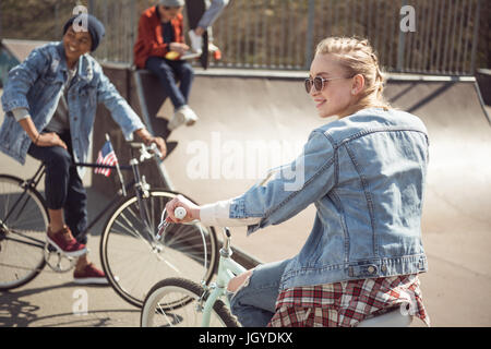 teenagers having fun and riding bicycles in skateboard park, bike riding city concept Stock Photo